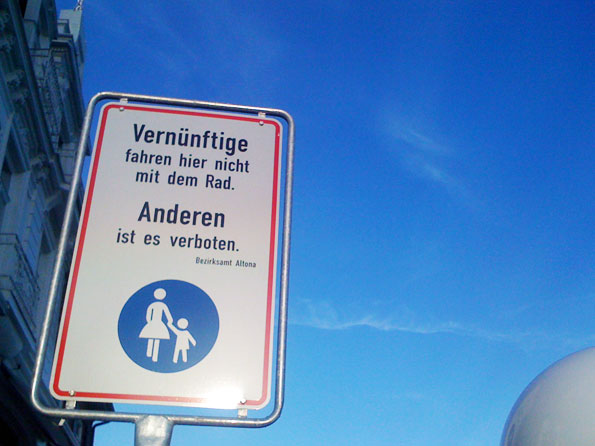 Foto von einem Schild mit der Aufschrift: "Vernnftige fahren hier nicht mit dem Rad. Anderen ist es verboten. Bezirksamt Altona